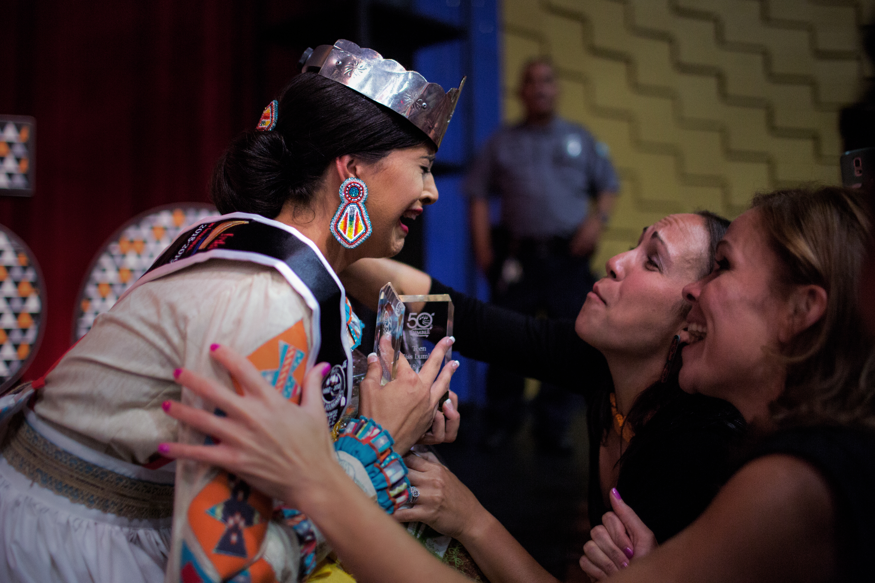 Teen Miss Lumbee winner Jacobs kneels at the edge of the stage after sheâs pronounced the winner.